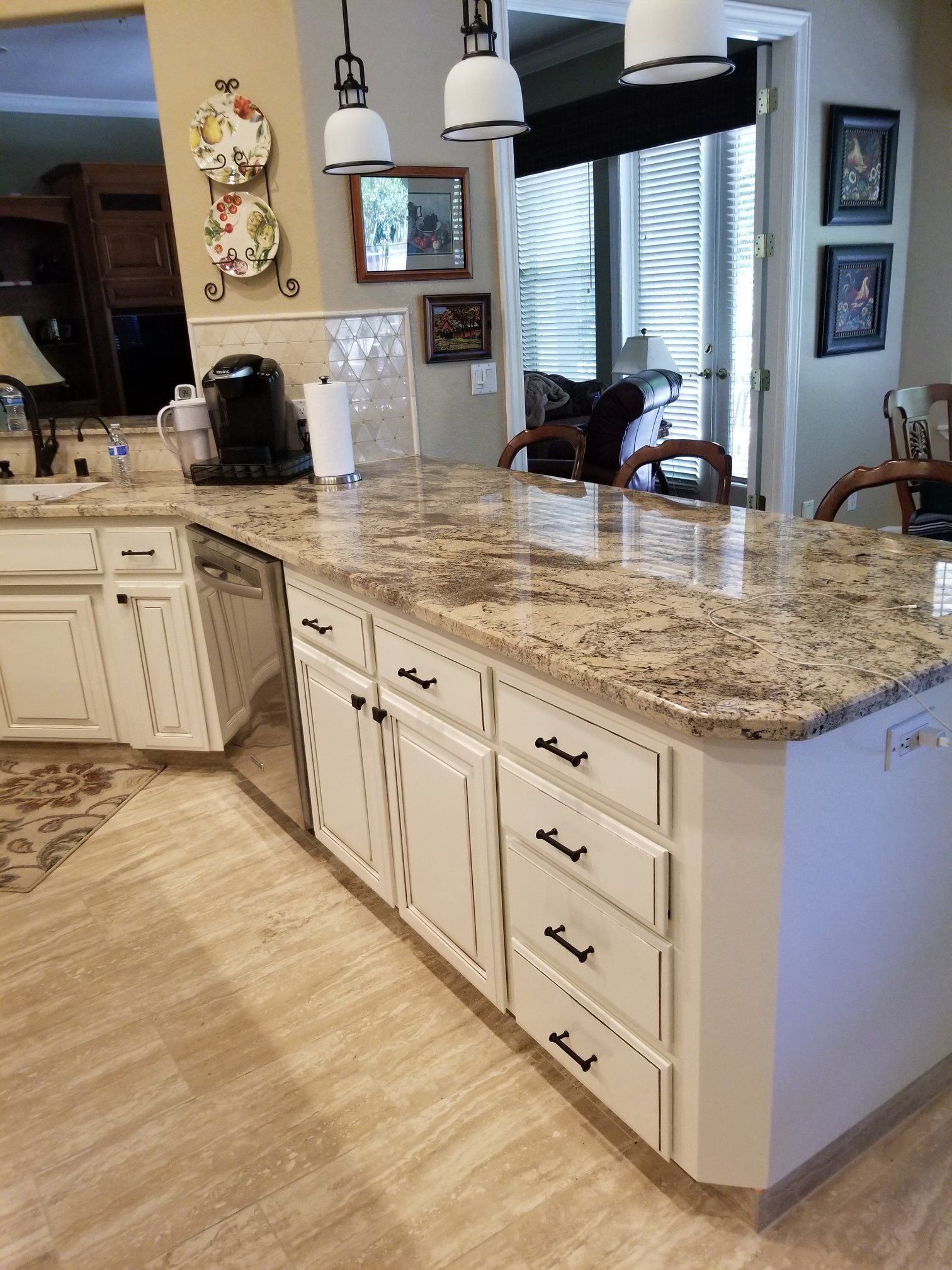 A kitchen with white cabinets and granite counter tops.