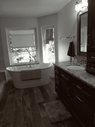 A black and white photo of a bathroom with a tub and sink