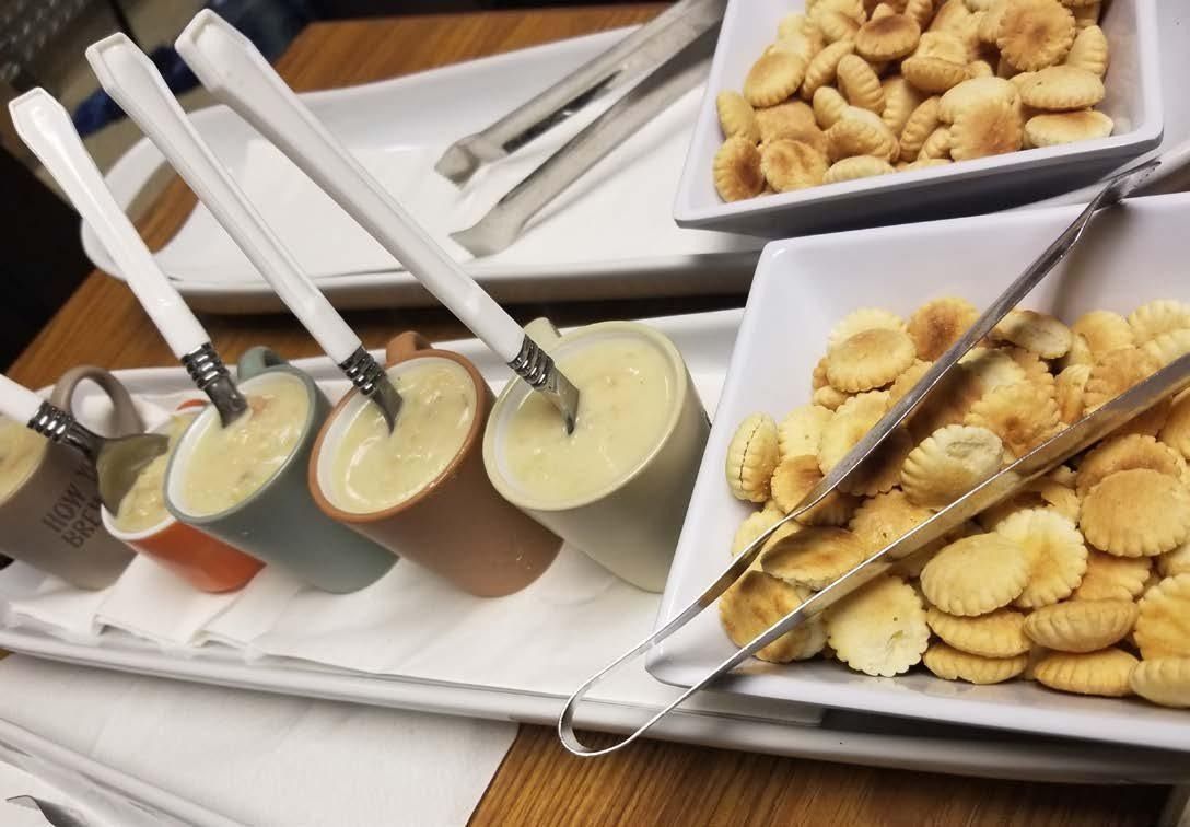 Dessert buffet with small cheesecake cups and platters of cookies on a white table setup