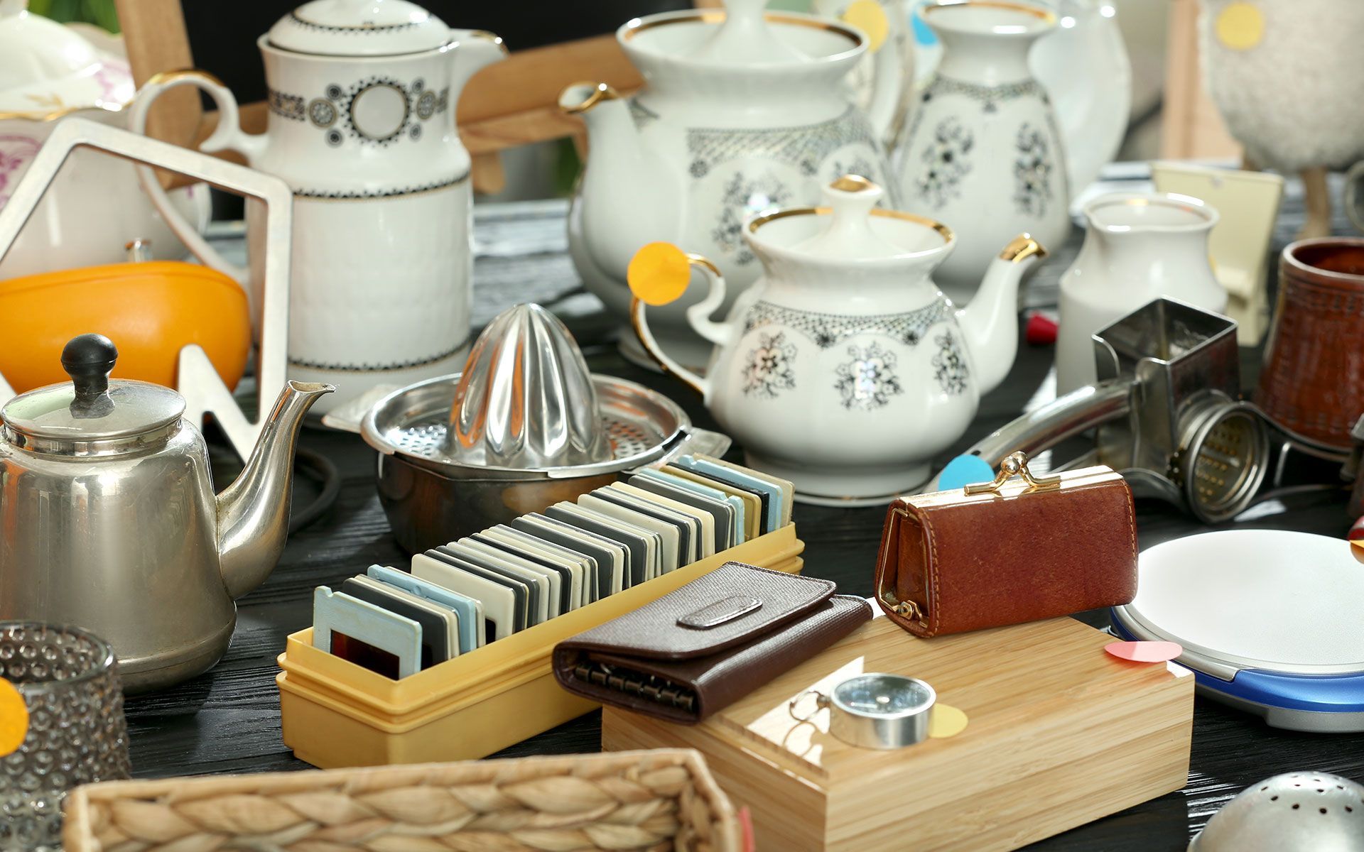 A table topped with a variety of items including teapots and a wallet.