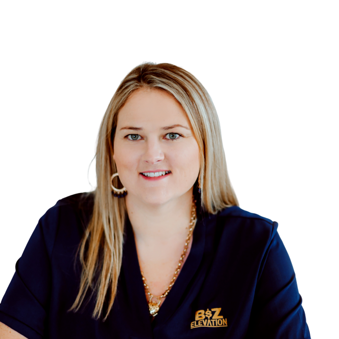 A professional headshot of a person with blonde hair wearing a navy blue collared shirt with a gold logo and necklace.