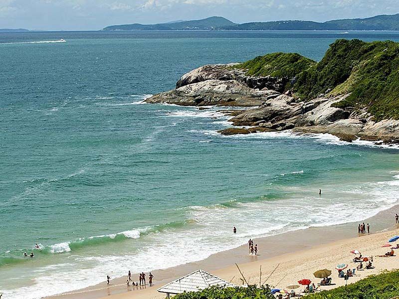Uma vista aérea de uma praia com pessoas e guarda-sóis