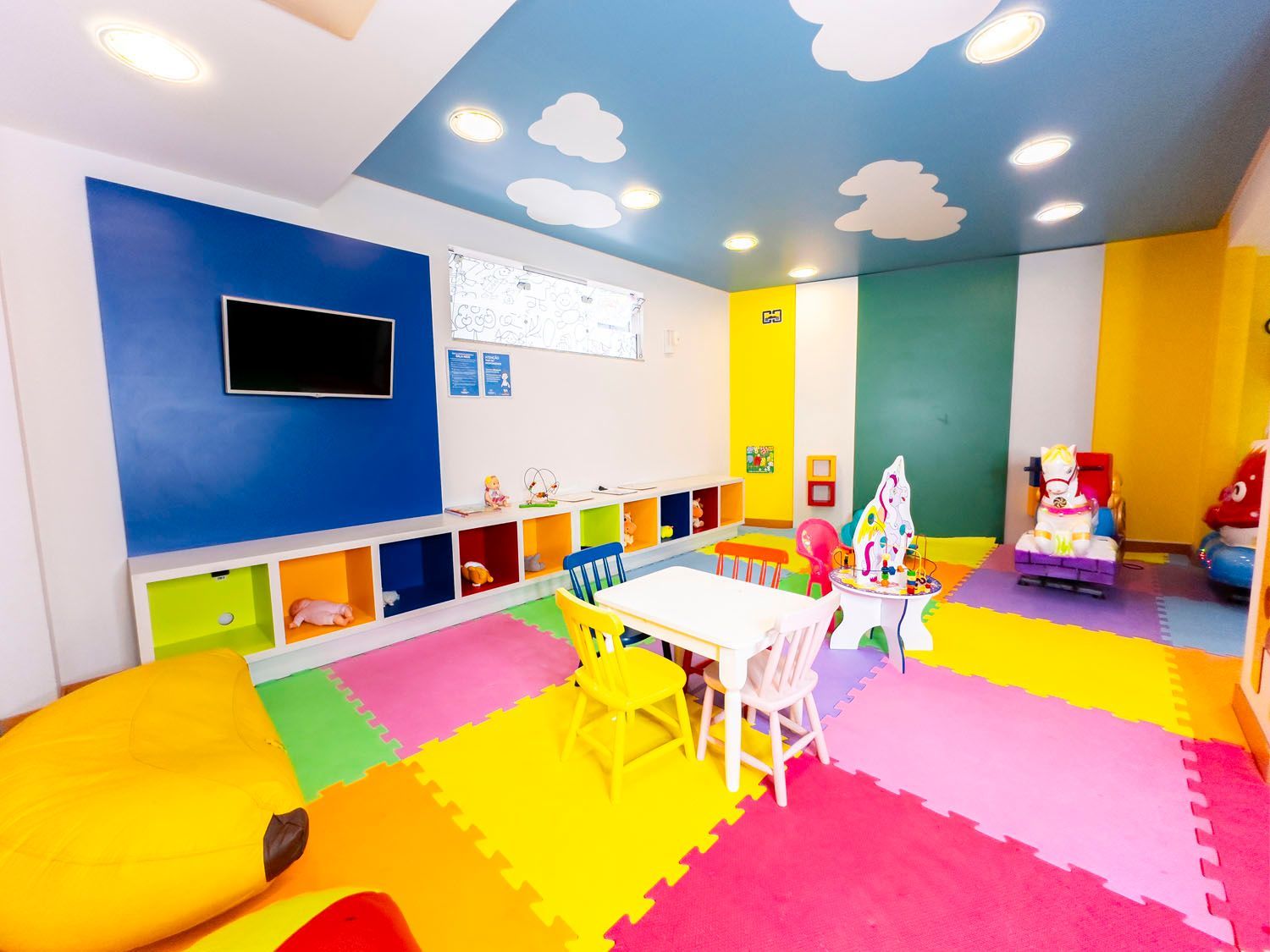 Um quarto infantil colorido com mesa e cadeiras.