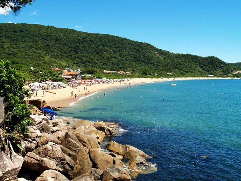 Um grande corpo de água com uma praia ao fundo