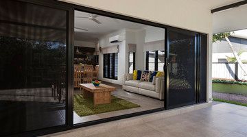 A living room with a couch , coffee table , and sliding glass doors.