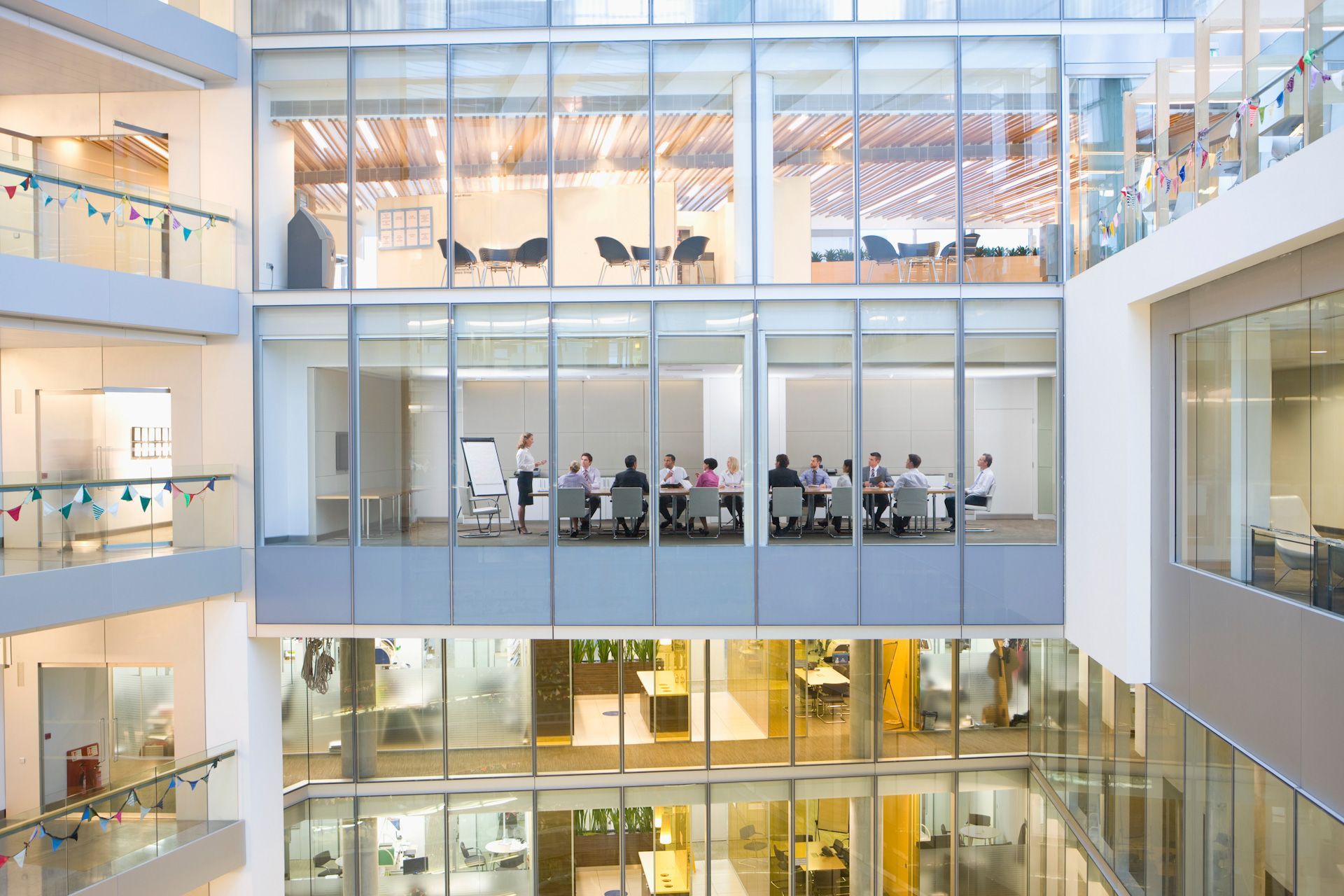 A group of people are sitting at tables in an office building.