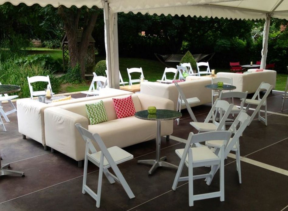 A tent with tables and chairs underneath it
