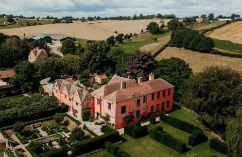 An aerial view of a large house surrounded by trees and fields.