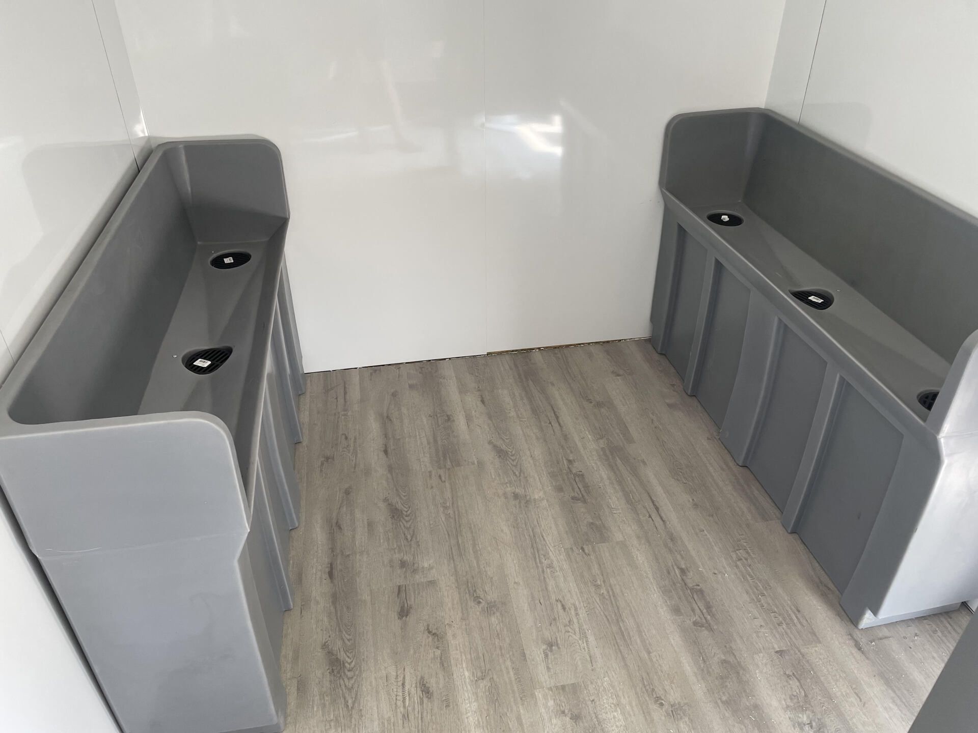 Empty white interior with two gray bench seats facing each other