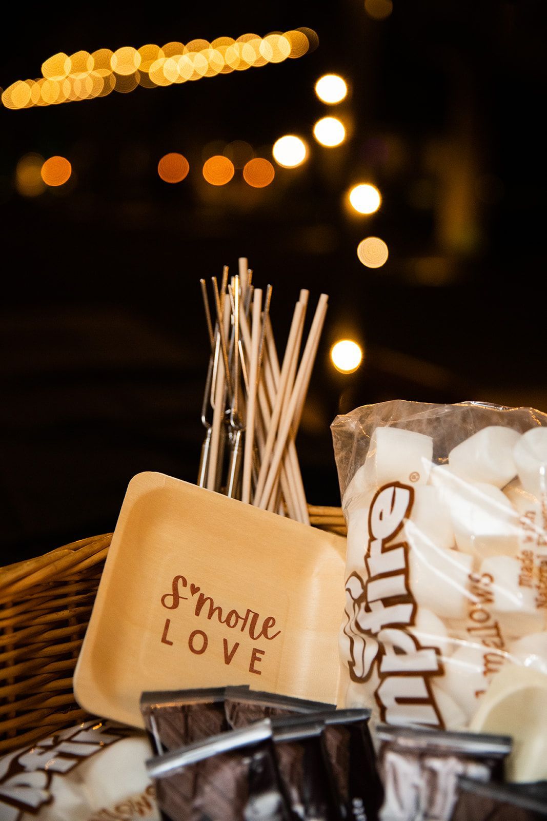 Assorted snacks and cookies on a table with warm bokeh string lights in the background