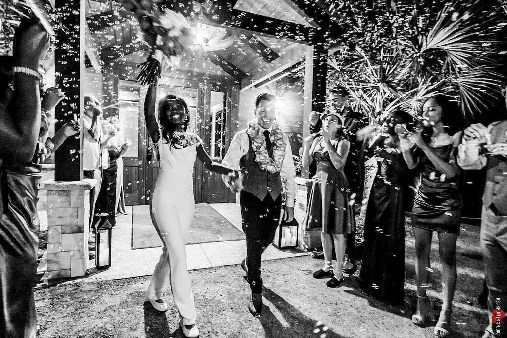 Crowd celebrating at a party with fireworks overhead and a couple dancing in the center