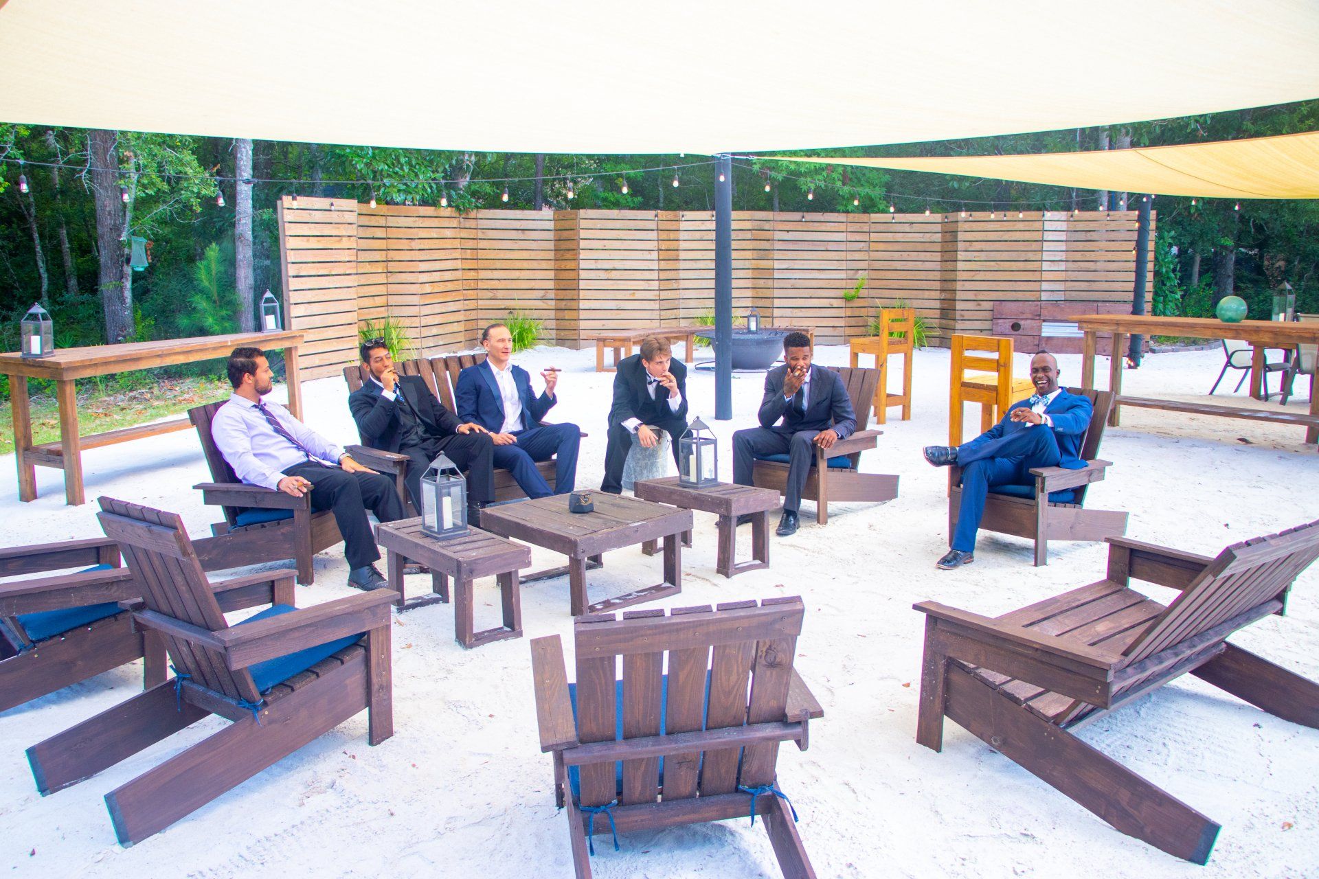 People seated on wooden chairs around a fire pit in an outdoor lounge area
