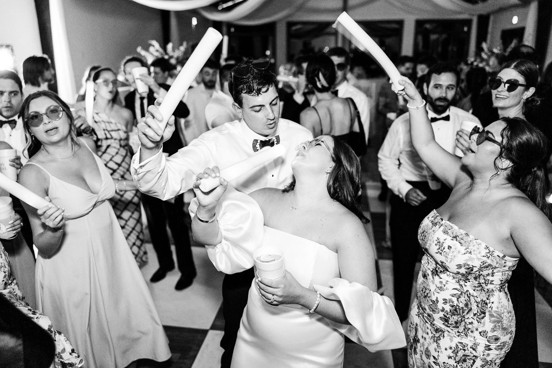 Crowded dance floor at a lively party, with guests dancing and smiling amid balloons and streamers