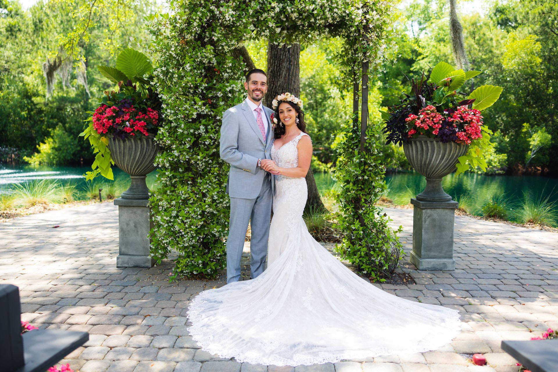 Bride and groom in a garden wedding portrait beneath a flower-covered arch