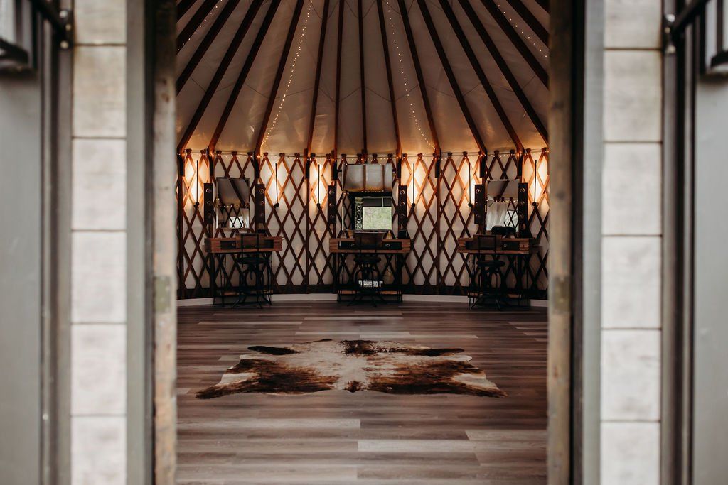 Elegant room with draped walls, a central chair, and patterned rugs on a wooden floor.
