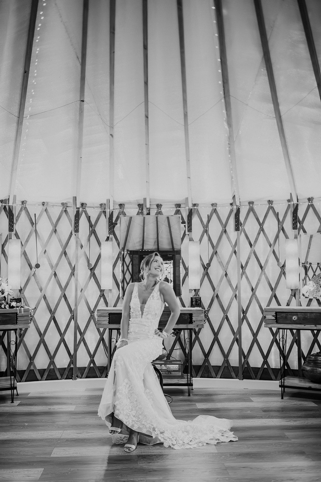 Bride in a white gown poses in a yurt-like interior with patterned walls and tall drapes.