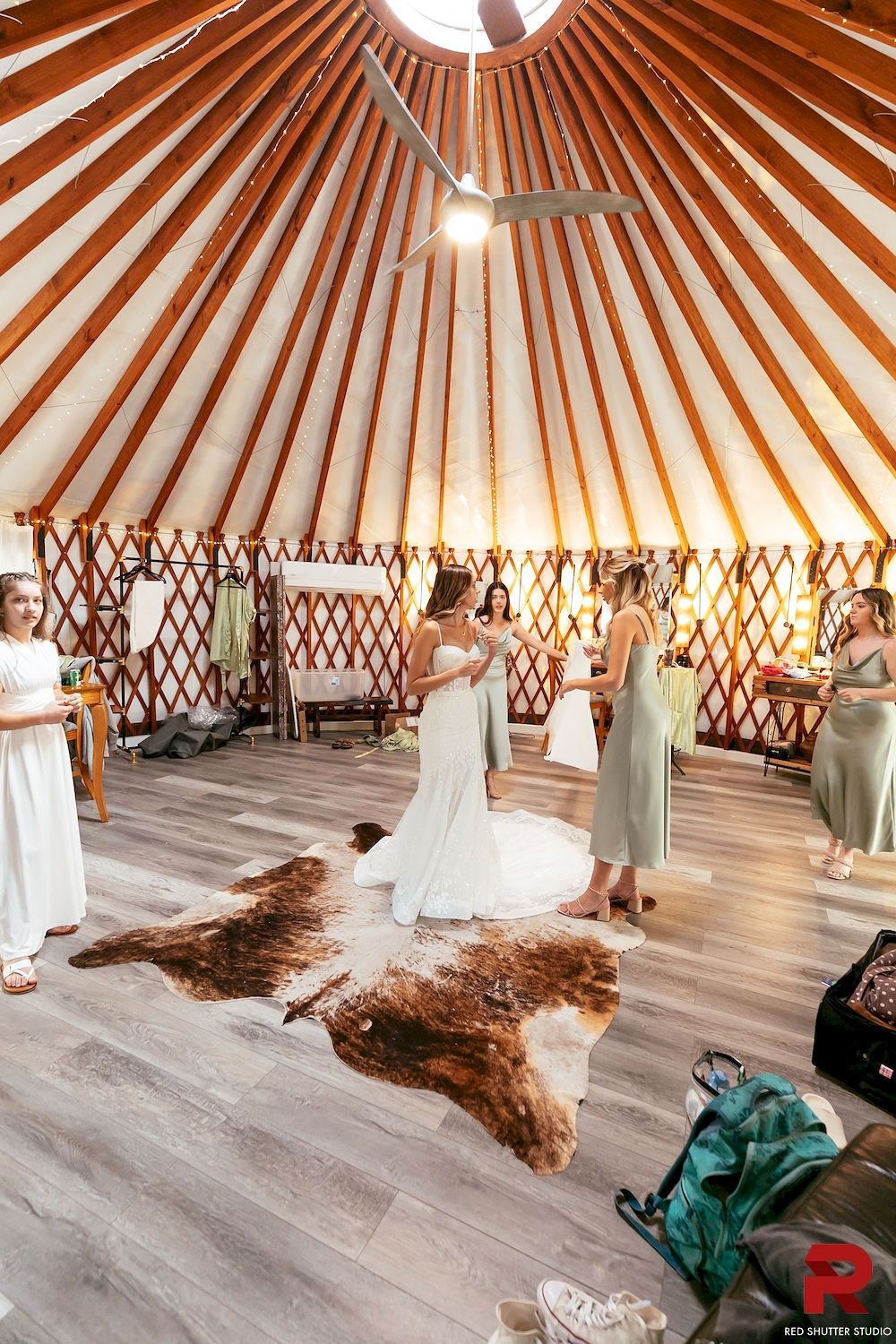 Guests in a decorated yurt venue standing on a patterned rug during a social event