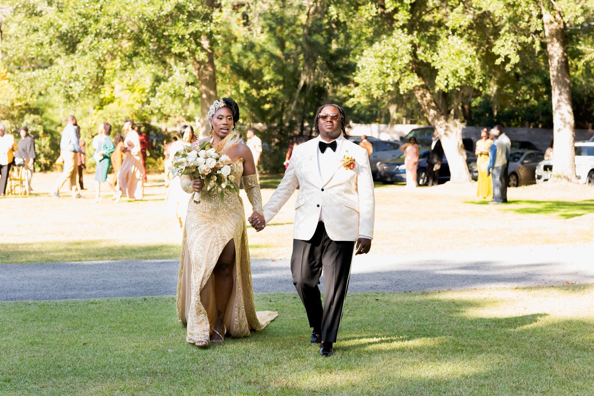 Bride and groom walking arm-in-arm on a grassy path outdoors at a wedding