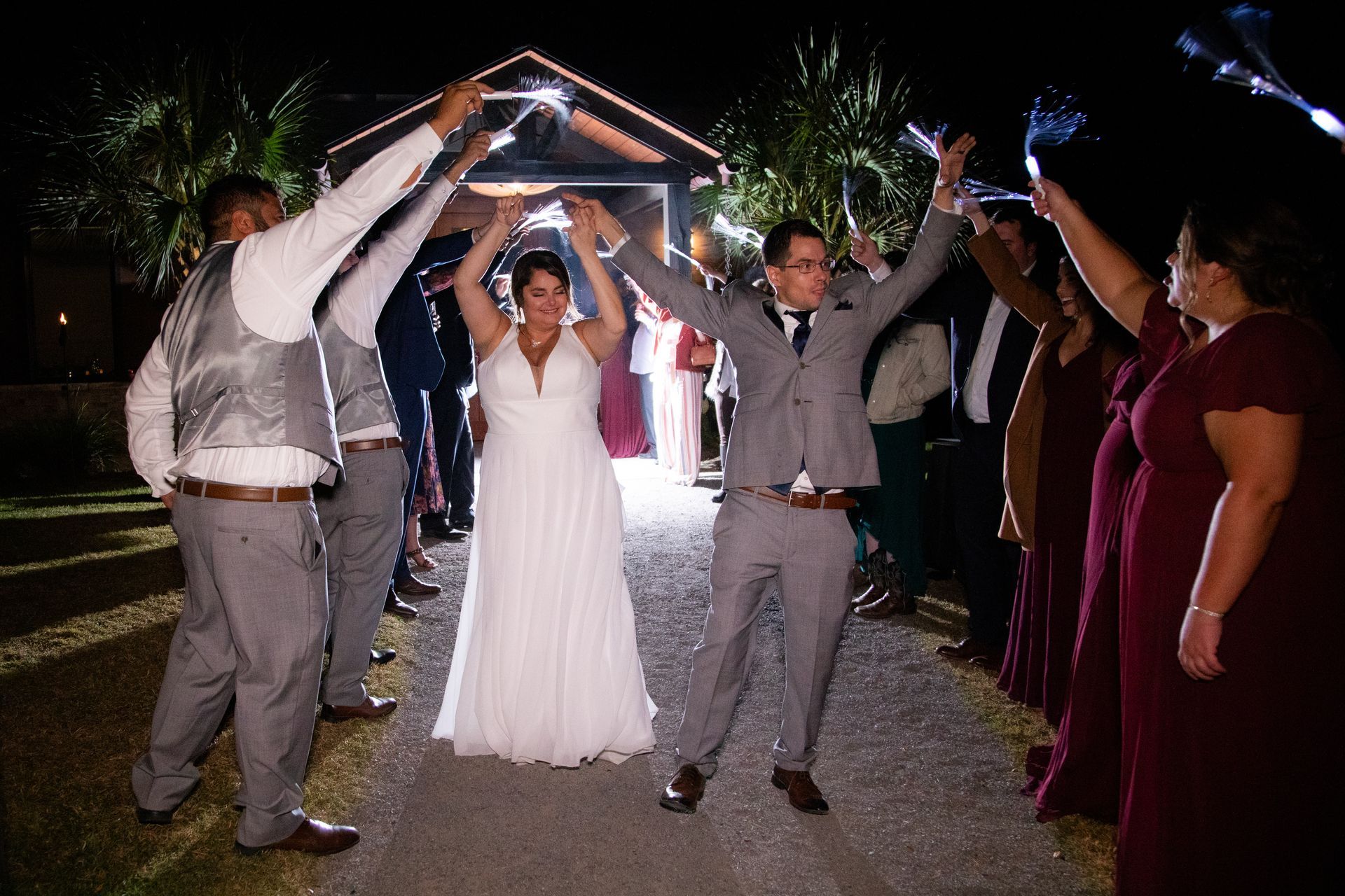 Wedding couple under sparklers held by guests at night outdoors