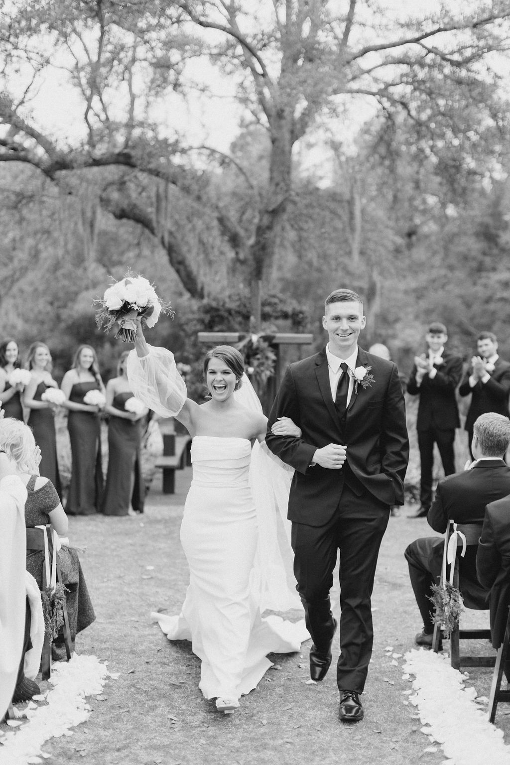 Bride and groom walking down an outdoor aisle after their wedding ceremony