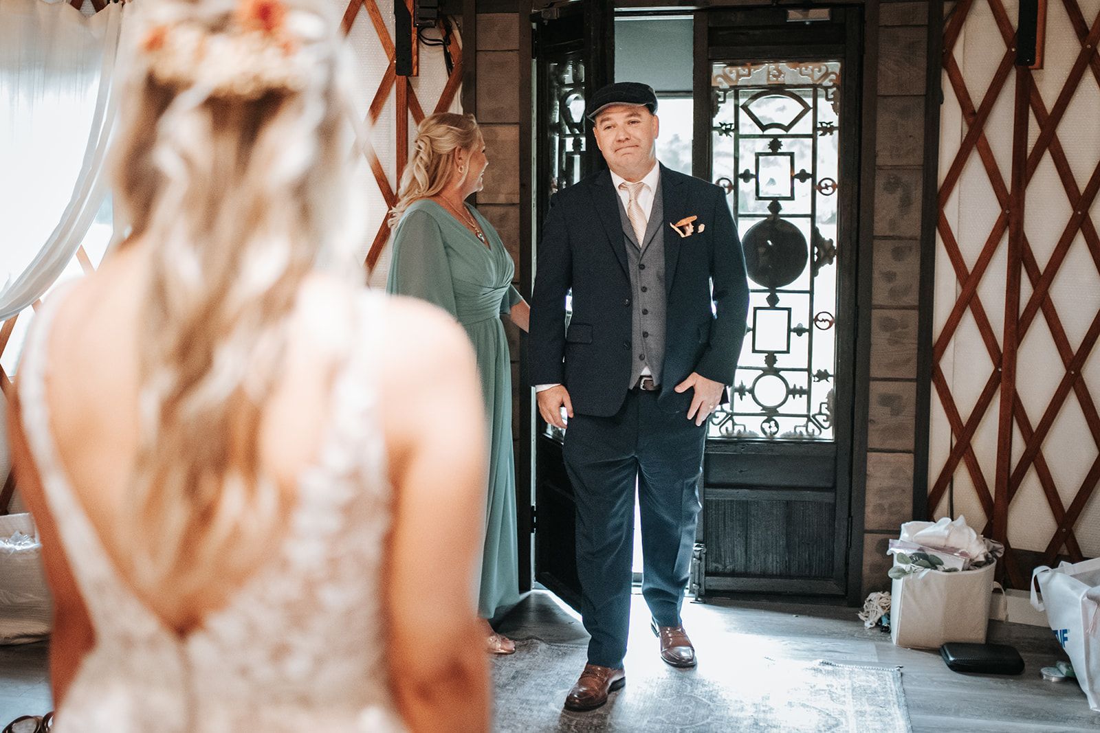 Bride stands before a groom at the doorway of a decorated indoor venue.