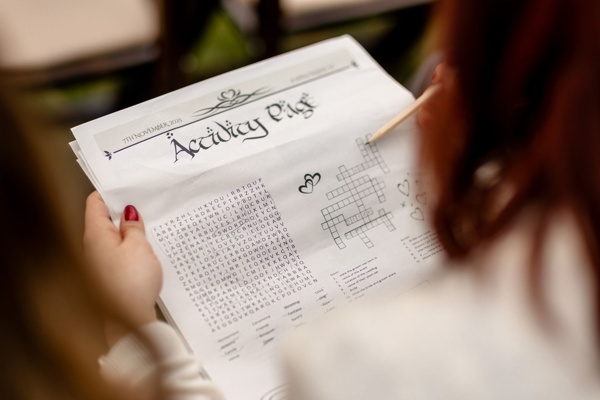 Person holding a handwritten calendar or schedule on paper in a warm indoor setting