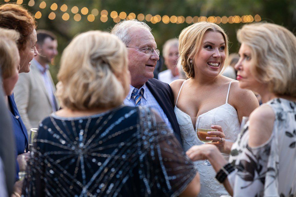 Guests chatting at an outdoor evening party with string lights in the background