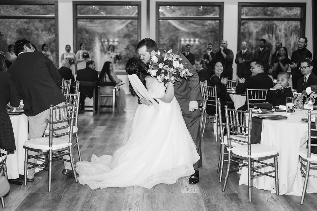 Bride and groom dancing at a black-and-white wedding reception in a banquet hall