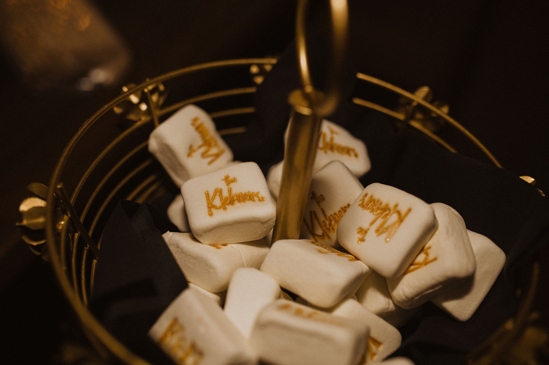 Marshmallows with caramel drizzle in a dark dessert bowl, lit warmly