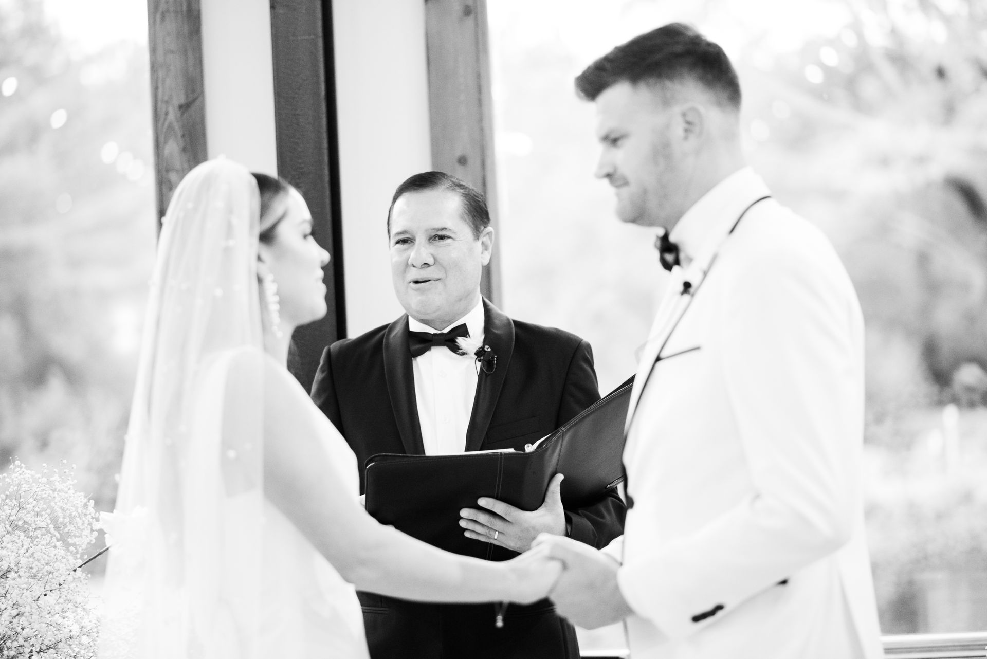 Bride and groom exchanging vows with officiant during outdoor wedding ceremony