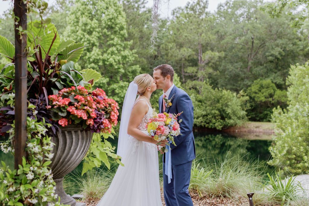 Bride and groom holding a bouquet during an outdoor wedding ceremony in a garden