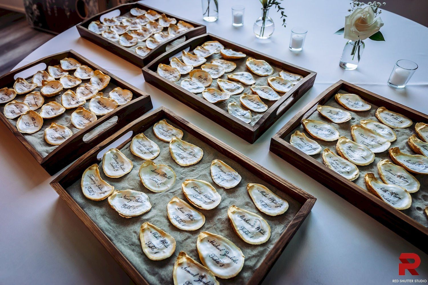 Trays of decorated pastries on a white table at a buffet setup