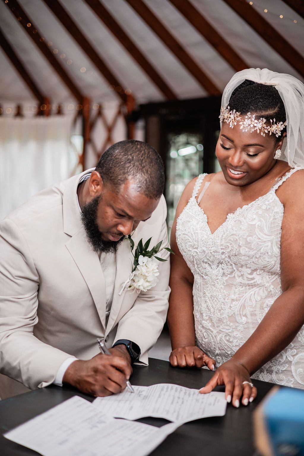 Bride and groom sign marriage documents at a wedding ceremony