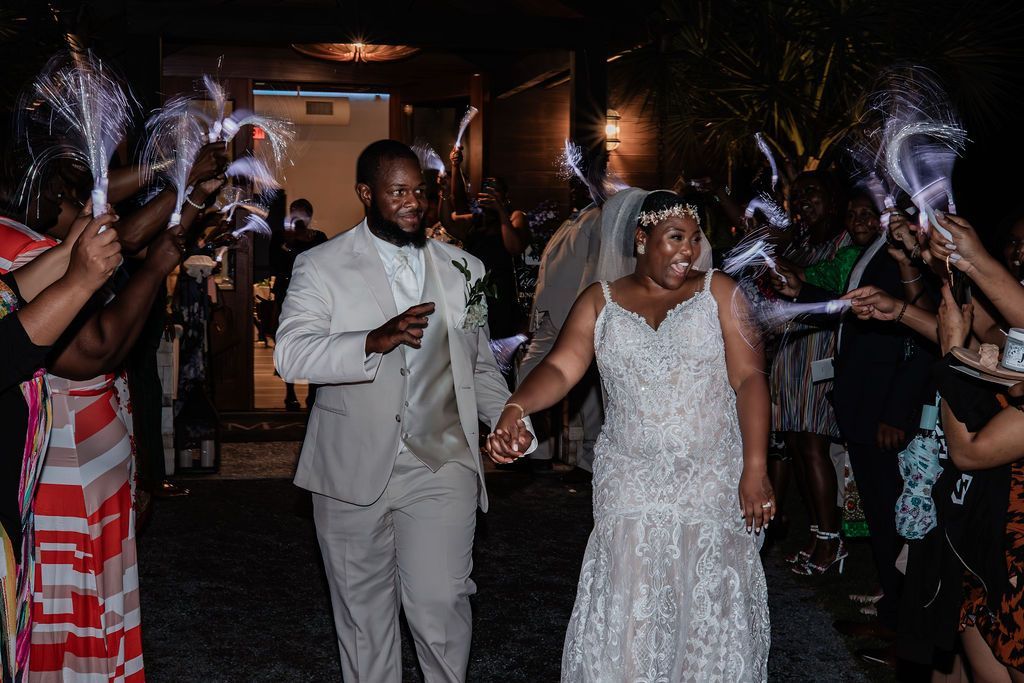Wedding couple walking through a sparkler send-off at night