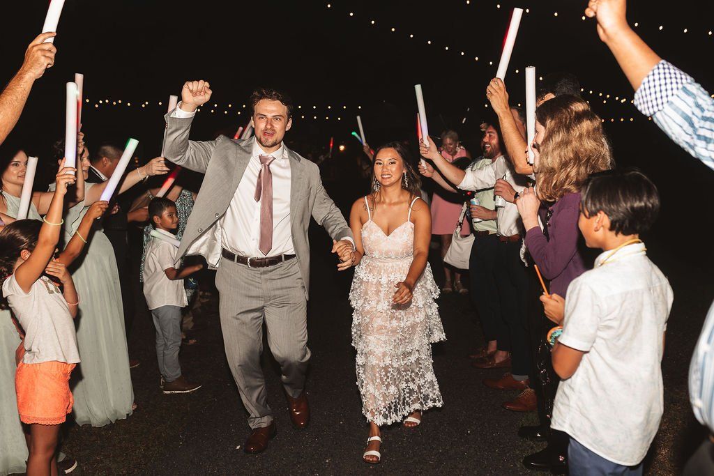 People dancing at a night celebration, waving glow sticks in a lively crowd