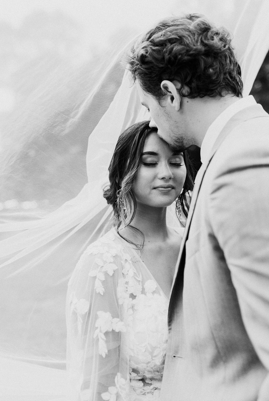 Bride and groom sharing a tender moment in black-and-white wedding portrait