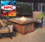 Patio fire pit with a flame, surrounded by cushioned outdoor chairs and a brick base