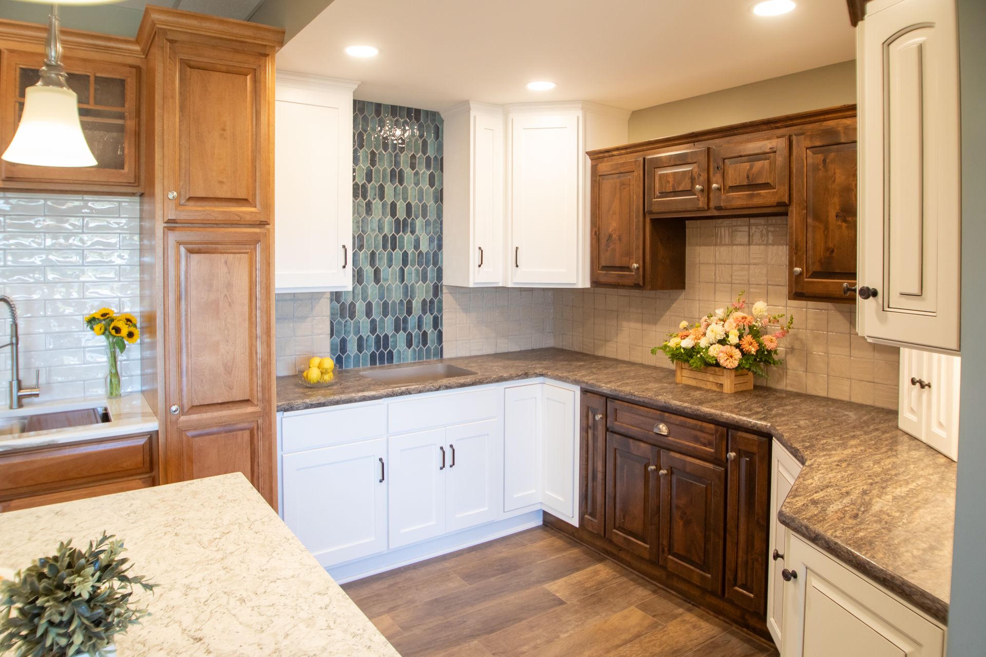 Kitchen with wooden and white cabinets, countertops, and a decorative tile backsplash.
