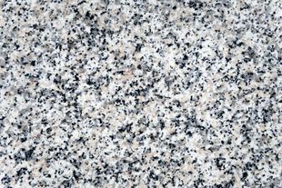 Close-up of granite surface with white, gray, and black speckles.