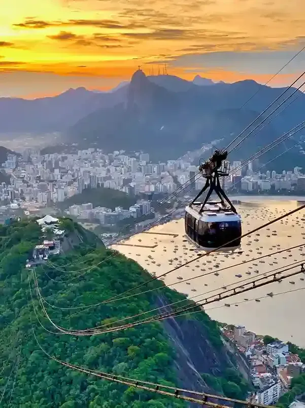 Teleférico sobre o Rio de Janeiro ao pôr do sol, com o Pão de Açúcar e a cidade lá embaixo