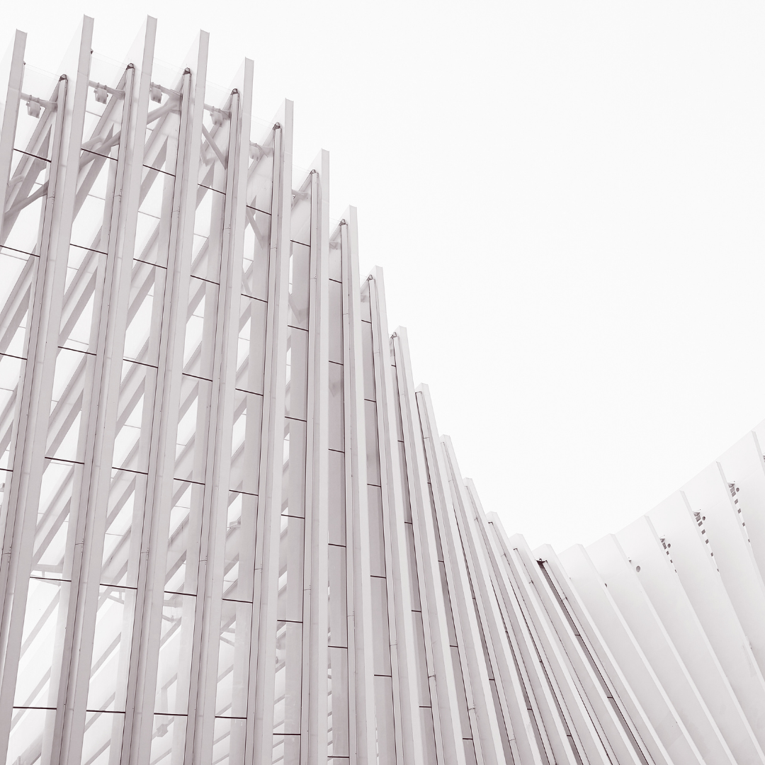 White modern architectural structure with repeating curved beams against a bright sky