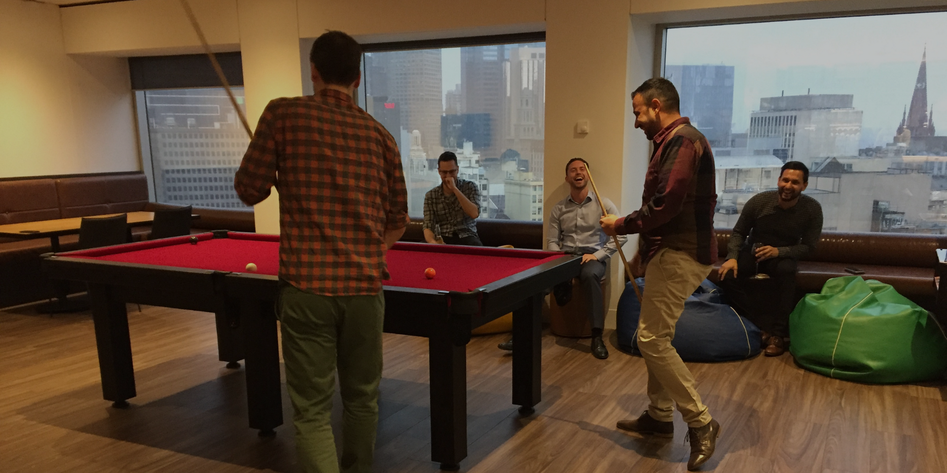 The team playing pool in a room.