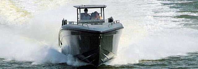 Speedboat cutting through water, leaving a white wake behind it.
