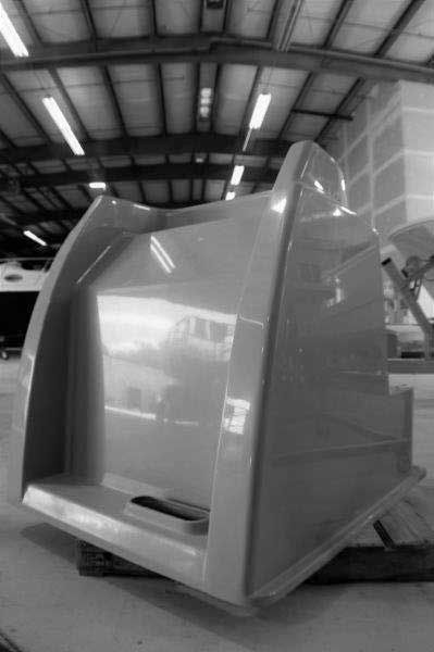 Large gray industrial machine in a warehouse with a sloped open front and reflective panels