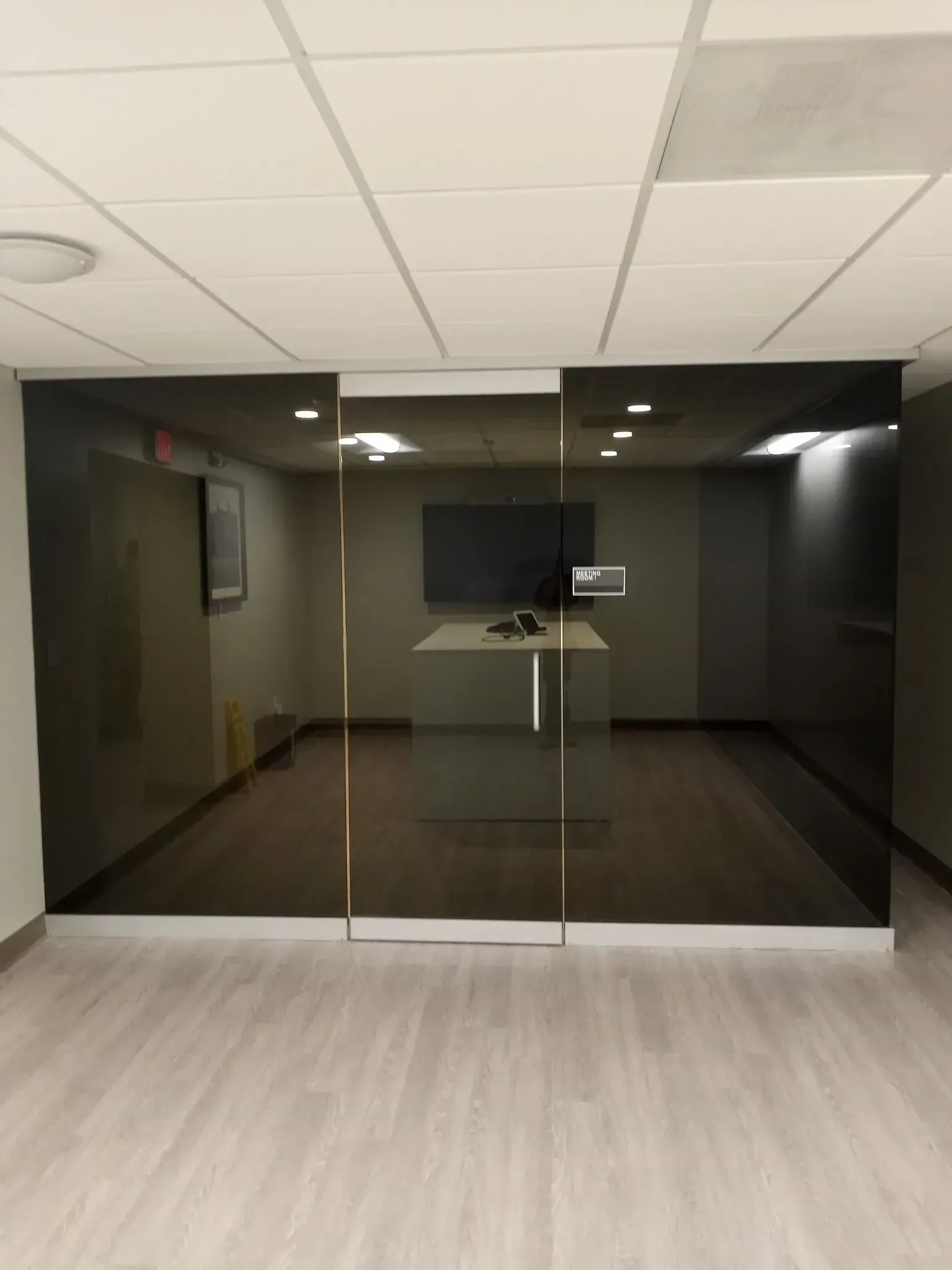 Modern glass building entrance with double doors and reflective windows.