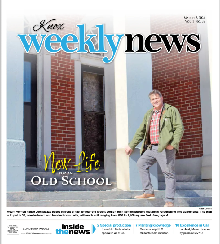 A man standing on the steps of an old brick school building, with the title 