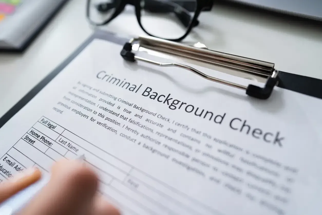 Hand filling out a criminal background check application form in Canada