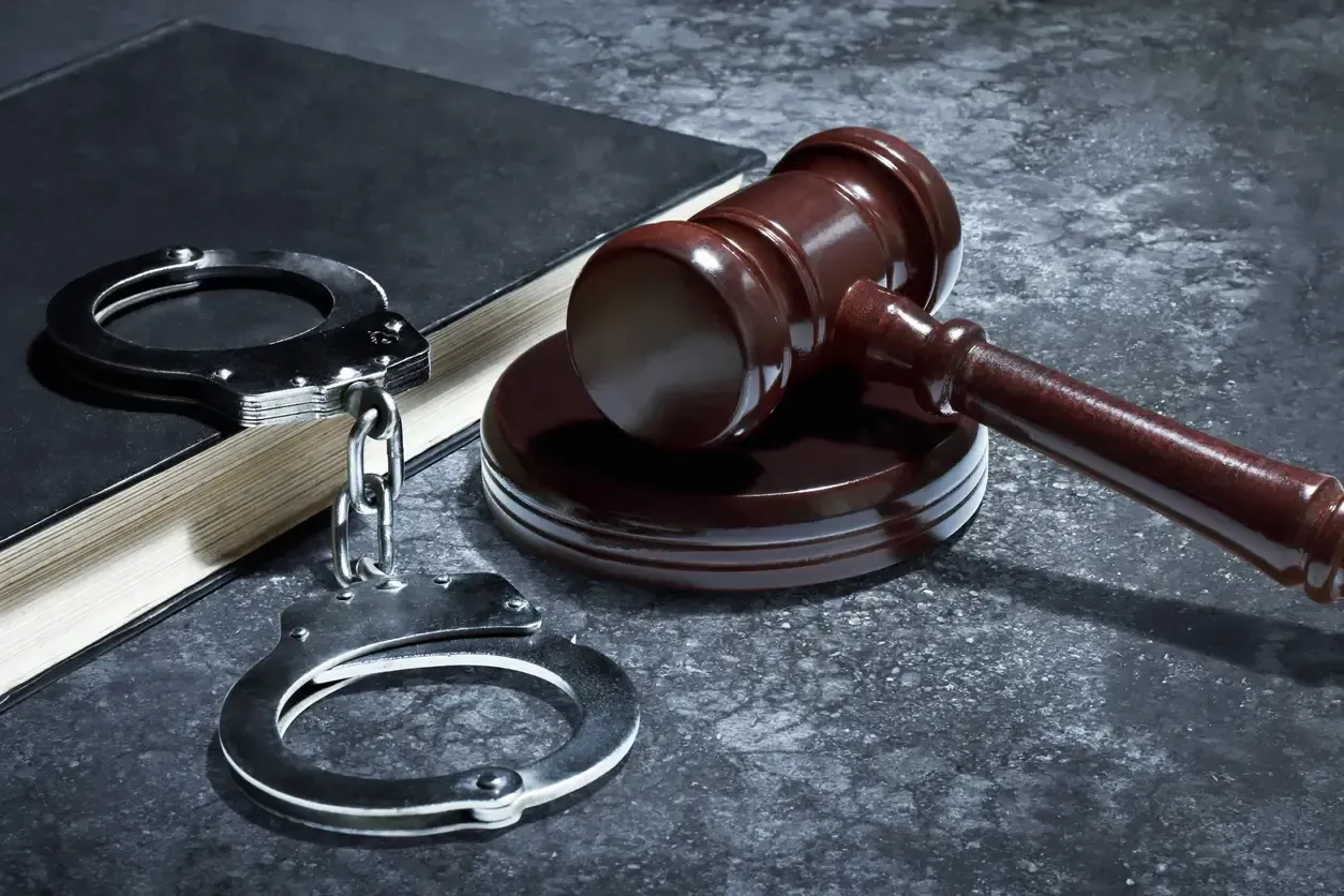 Handcuffs on a law book with a gavel representing criminal records and justice in Canada