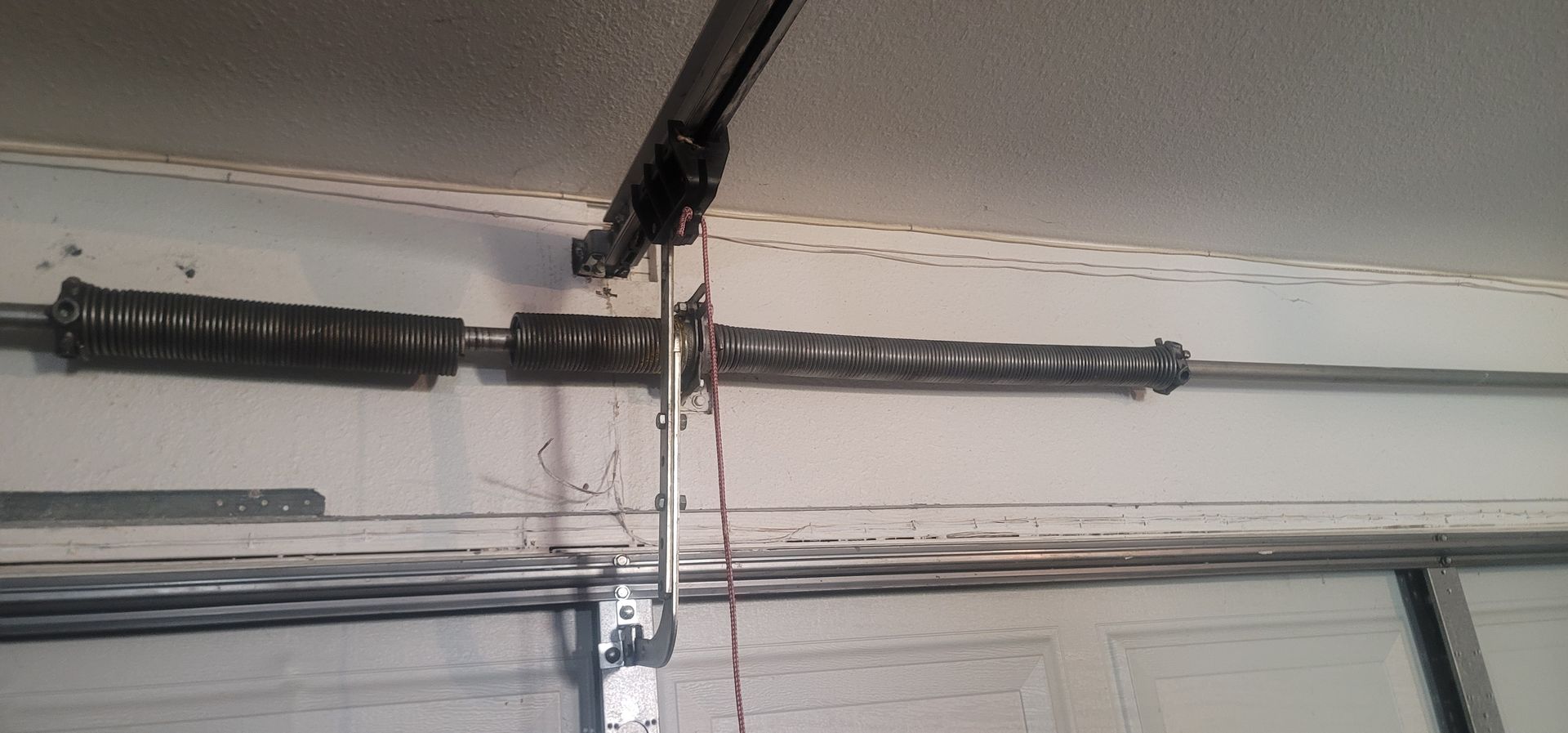 Close-up of a garage door torsion spring being serviced near Winchester, CA