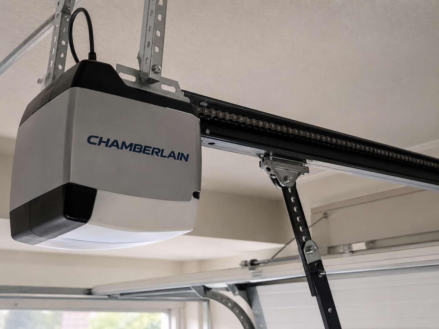 Chamberlain garage door opener mounted on the ceiling with drive rail and arm connected to the door